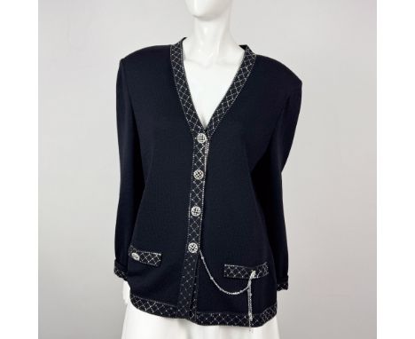 Black knit sweater jacket designed for evening wear and embellished with silver button accents and sequined borders. Accent c