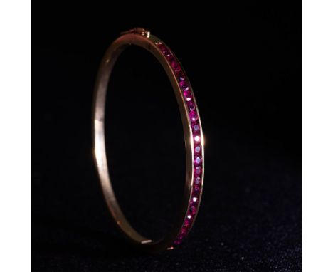 Stunning bangle bracelet in 18K gold with 1.50ct rubies. Measures 2.25" x 2" inside when closed. Weight 20.59 grams. Note: th