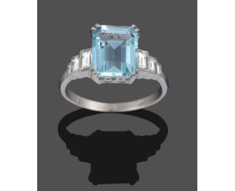 An Art Deco Style Aquamarine and Diamond Ring, an emerald-cut aquamarine in a white double claw setting set above a pierced g