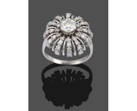 A Diamond Cluster Starburst Ring, a round brilliant cut diamond within a frame of curved rows of eight-cut diamonds alternati