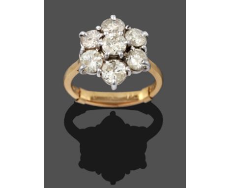 An 18 Carat Gold Diamond Cluster Ring, seven round brilliant cut diamonds in white claw settings, to a yellow tapered shoulde