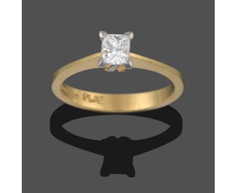 An 18 Carat Gold Diamond Solitaire Ring, the princess cut diamond in a white claw setting, to a yellow knife edge shoulder pl