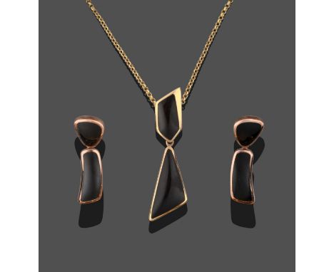 A 9 Carat Gold Jet Pendant on Chain, an irregular asymmetric shaped piece of jet suspends a larger piece in yellow rubbed ove