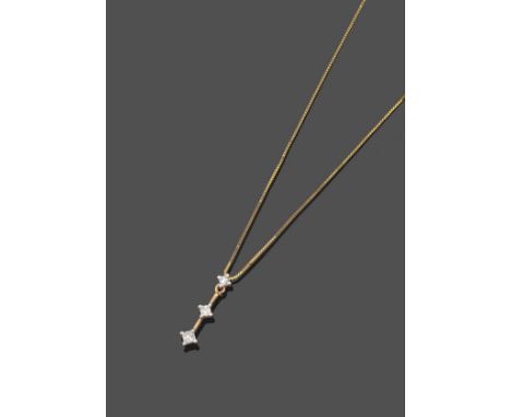 A Diamond Pendant on Chain, a trio drop of princess cut diamonds in white claw settings, spaced by fixed yellow bars, on a ye