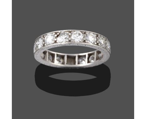 A Diamond Eternity Ring, the round brilliant cut diamonds in white claw settings, with engraved sides, total estimated diamon