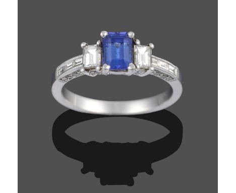 An Art Deco Style Tanzanite and Diamond Three Stone Ring, the central emerald-cut tanzanite within two baguette cut diamonds 