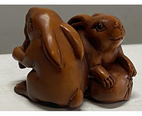 A boxwood netsuke depicting two rabbits. Signed 