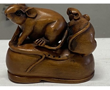 A boxwood netsuke depicting two rats on a shoe. Signed to base. 