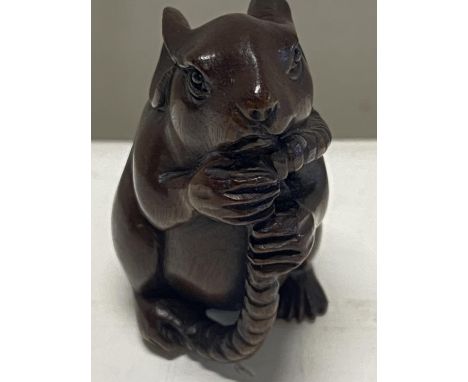 A hard wood netsuke in the form of a rat 