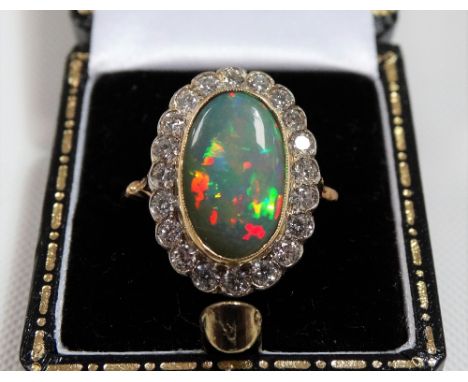 Good 18ct gold opal and diamond cluster ring, the opal of 3ct spread approx and displaying colours of red, green, yellow and 