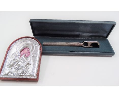 Silver engine turned handled bottle opener within fitted case together with a silver front religious icon (2)