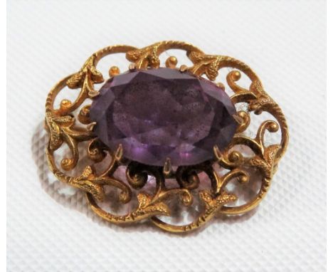 Yellow metal foliate scroll openwork amethyst set brooch, width 25mm, weight 4.6g approx.