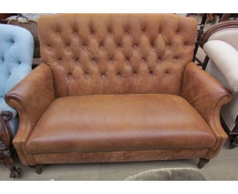 A Brown leather two seater settee with button back upholstery