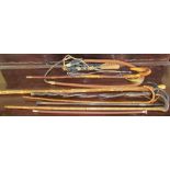 A collection of walking sticks and a whip