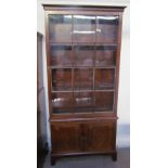 A Regency style mahogany bookcase with a moulded cornice and single glazed door with glazing bars,