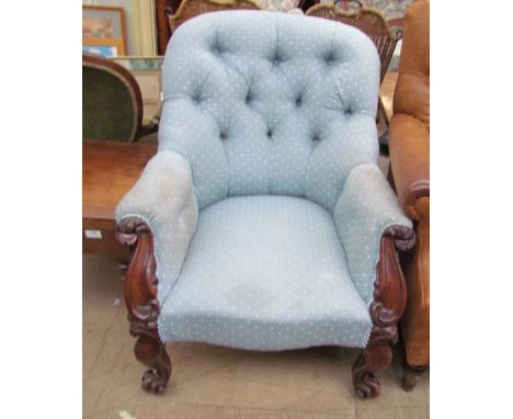 A Victorian button back upholstered library chair with carved from on scrolling legs and casters