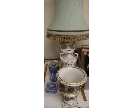 A continental porcelain urn with winged lion handles together with a pair of floral decorated vases, a table lamp, Wedgwood j