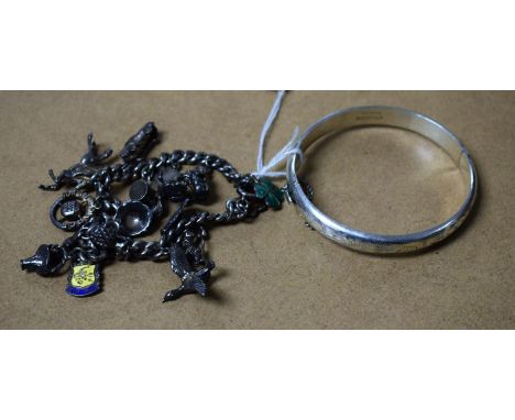 A silver charm bracelet with assorted charms; a silver bangle (2)