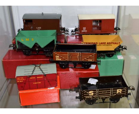A Hornby Gauge 0 Goods Brake Van, LMS; another NE; a Wagon with Sheet Rail, LMS; a No.50 Rotary Tipping Wagon, Trinidad Lake 