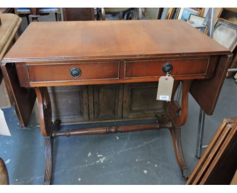 A reproduction yew wood sofa table on lyre end standards.