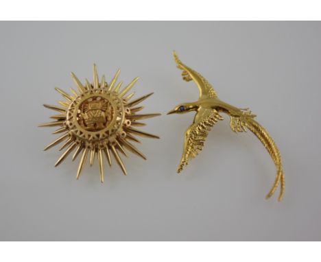 A yellow metal sunburst pendant, pierced with an Inca fetish, stamped 18k; together with a bird-of-paradise brooch set with a