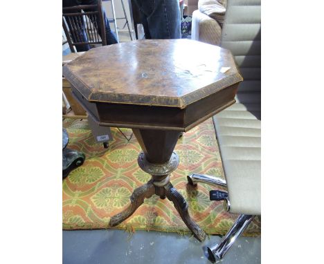 A Victorian walnut work table, the octagonal hinged top above a tapering work well, on a tripod base with cabriole legs endin