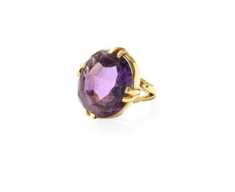 An 18 Carat Gold Amethyst Ring, the oval mixed cut amethyst in a yellow double claw setting, to a forked shoulder plain polis