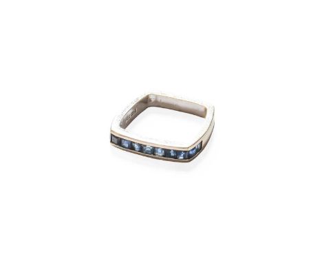 An 18 Carat White Gold Sapphire Half Hoop Ring, the calibré cut sapphires in a channel setting, finger size E (approximately)