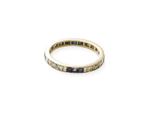 A Sapphire and Diamond Eternity Ring, trios of calibré cut sapphires spaced by trios of round brilliant cut diamonds, in whit