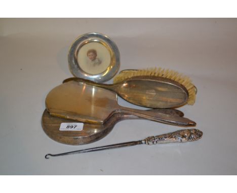 Four various silver mounted dressing table items, silver handled button hook and a small circular silver photograph frame