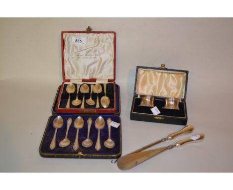 Two cased sets of silver coffee spoons together with a cased pair of silver napkin rings, a silver handled button hook and sh