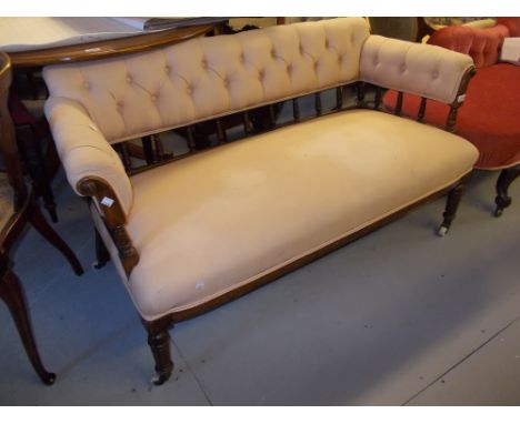 Late Victorian walnut and button upholstered two seater sofa with a spindle back and sides raised on turned tapering supports