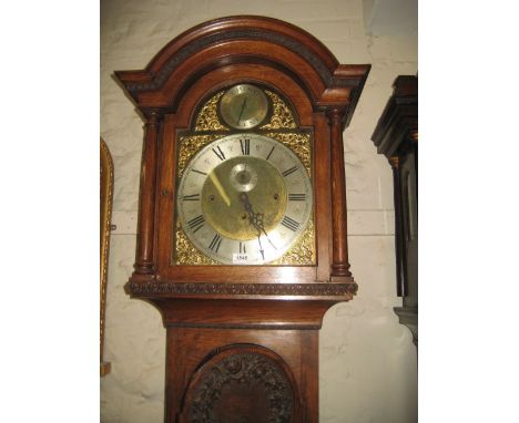 Late Victorian oak longcase clock, the arched hood with turned columns above an arched door with floral carved panels and a p