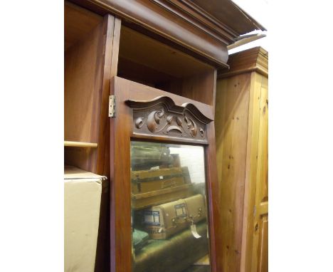 Art Nouveau mahogany wardrobe having two small carved panelled doors above an arrangement of drawers, flanked by two mirrored