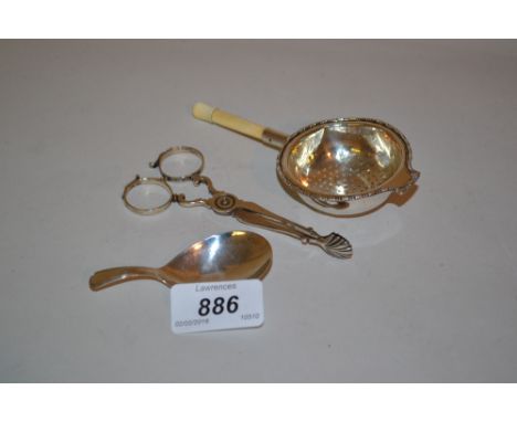 Pair of antique silver sugar nips, an early 19th Century silver caddy spoon and an ivory handled silver tea strainer