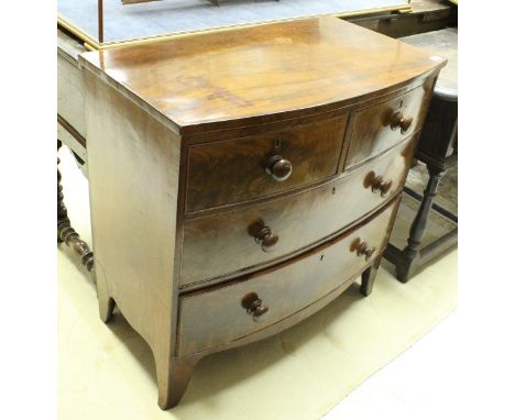 An early Victorian mahogany bow front chest, the plain top above two short and two long drawers with turned knob handles rais