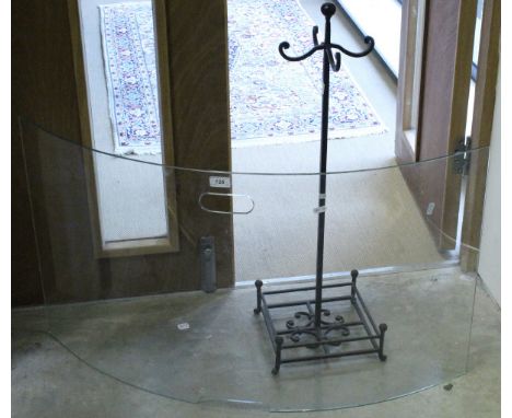 A cast iron stand and a curved glass fire screen