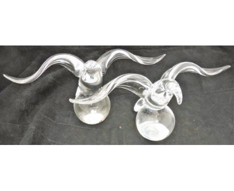 A pair of Steuben clear glass paperweights as eagles on balls, signed