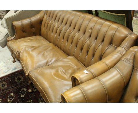 A modern leather three piece suite with button back upholstery to the scroll arms, raised on carved cabriole legs