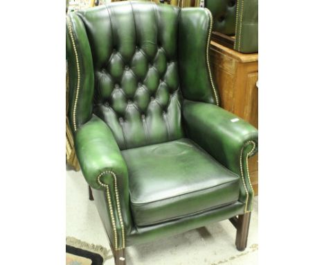 A pair of modern green leather button and studded wing back scroll arm chairs in the George III manner, together with two sim