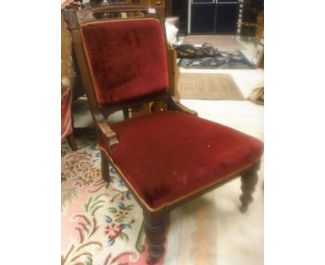 A Victorian ladies salon chair with red upohlstery raised on ringed and turned legs to brass caps and china castors, together