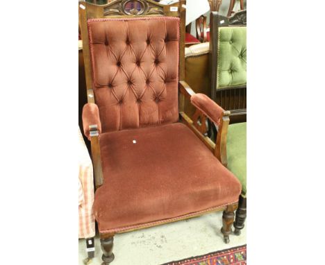 An Edwardian gents salon chair with carved back and button back upholstery raised on ringed nad turned front legs to brass ca