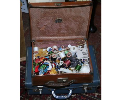Two vintage leather suitcases containing a quantity of sewing ephemera.