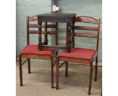A pair of upholstered ladder back chairs and a carved oak stool.