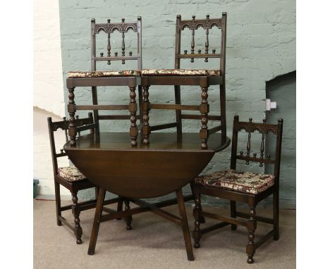 An Ercol dark drop leaf table and four chairs.