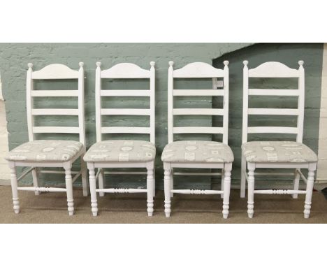 A set of four painted ladder back dining chairs with designer upholstered seats.