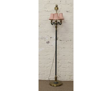A brass based three branch standard lamp and shade.