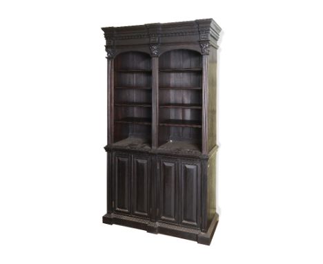 An 18th century style bookcase, having two banks of adjustable shelves above two pairs of panel doors, flanked by fluted colu
