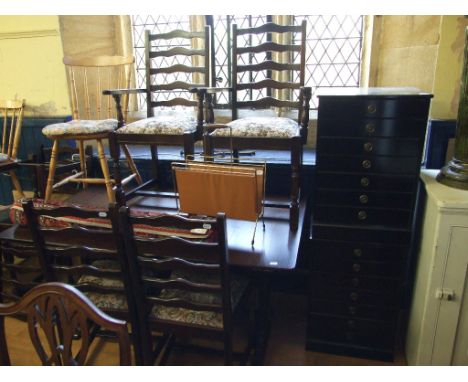 A pair of ebonised pedestal chests, of seven drawers, 48 cm wide, a dining table and six matching chairs (4+2), two stick bac