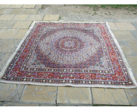 A Persian carpet, decorated a spreading central motif on a white ground, within a multi border, 200 x 197 cm